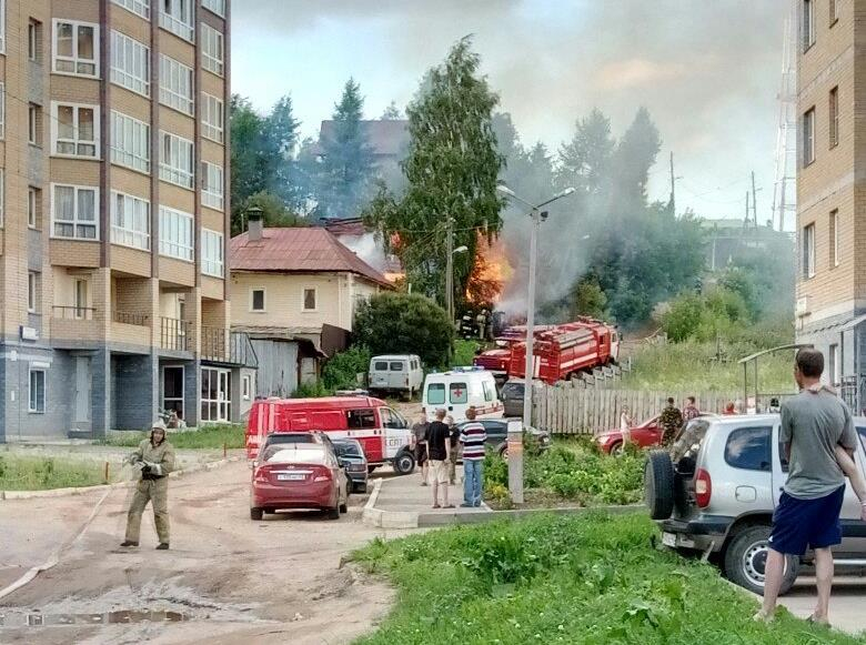 На улице Урицкого рядом с новостройками загорелся деревянный дом