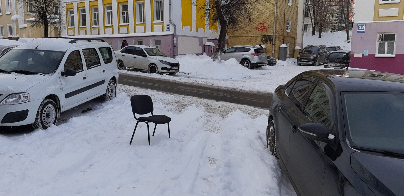 Фото дня: места на парковке у кировской прокуратуры занимают стульями