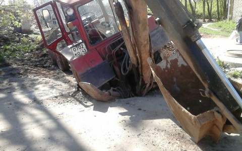 В Нововятске трактор провалился в яму на дороге, которую сам и выкопал